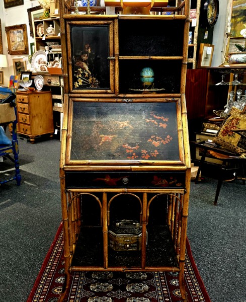 An antique bamboo secretary desk with chinoiserie lacquer panels on a Persian rug