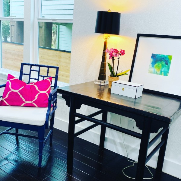 A vintage Chinese table with a cast brass lamp, orchid and blue bamboo chair