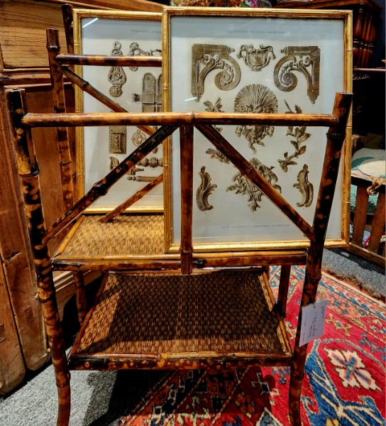 A tortoiseshell bamboo etagere holding framed architectural engravings